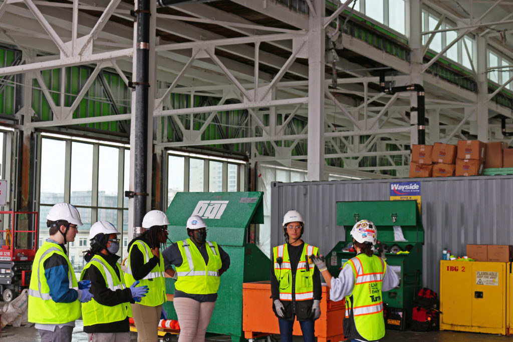 Students in hard hats visiting a construction site. 